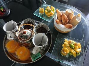 a glass table topped with a tray of breakfast foods at Chez Sab et chaton in Saint-Leu