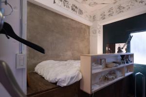 a bedroom with a bed and a shelf with dishes at apartment hotel Tasu Toco room 2 in Kichijōji
