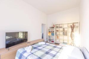 a white room with a bed and a tv at Nel Ghetto, Bologna by Short Holidays in Bologna +2 photos