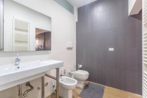 a bathroom with a sink and a toilet and a mirror at Nel Ghetto, Bologna by Short Holidays in Bologna