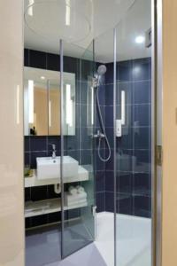 a bathroom with a glass shower and a sink at Skyline Grand Hotel - Near IGI New Delhi Airport in New Delhi