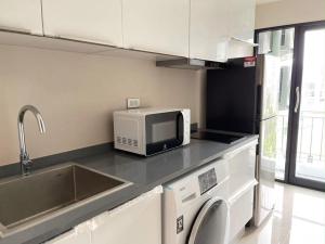 a kitchen with a sink and a microwave on a counter at CONDO UNIT With BALCONY in Bangkok +2 photos