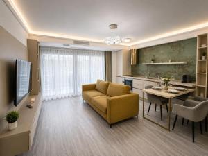 a living room with a yellow couch and a kitchen at WHITE TITANIC LUXURY Sea View & Studios in Mamaia Sat/Năvodari