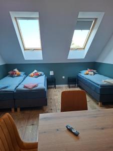 a attic room with two beds and a table at WINNICA 61 - Pokoje in Krotoszyce