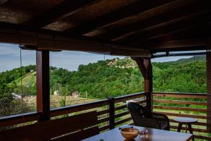 a balcony with a table and chairs and a view at Hill House Vrcelinija in Vuglovec