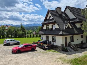 a red car parked in front of a house at Willa Zielona Polana in Czarna Góra