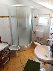 a bathroom with a shower and a sink and a toilet at Apartments Paloc - Green in Bol