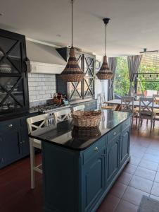 a kitchen with a blue island with a basket on it at Rusthall Prospect House in Speldhurst