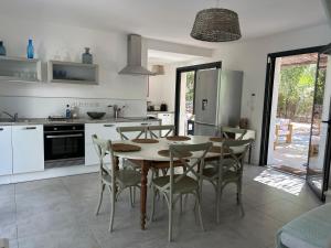 a kitchen with a table and chairs in a kitchen at LES VILLAS LECCI E MARE in Zonza