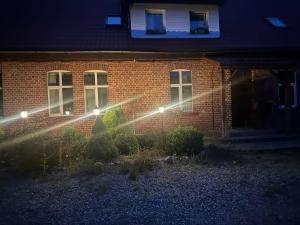 a house with lights in front of it at night at Izdebka in Bochowo