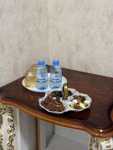a table with a plate of food and two bottles of water at Hotel Usmoon in Tashkent