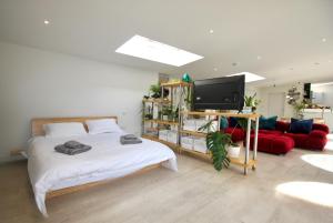 a bedroom with a bed and a tv and a couch at The Old Poolhouse in Beetham