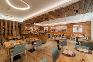a restaurant with wooden walls and tables and chairs at Albergo Maggiorina in Ledro