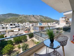 a balcony with a table and chairs and a view at AGORA luxury APARTMENT 3 in Loutraki