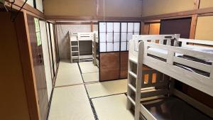 a room with two bunk beds and a hallway at ゲストハウス のまー in Komagane