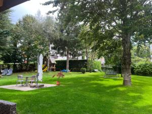 a green yard with a tree and a playground at Hotel alle Rose Family inspired garden and SPA in Cavedago +56 photos