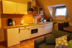 a small kitchen with yellow cabinets and a couch at Ferienwohnung Auf Mullay in Reil