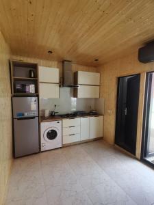 a kitchen with a refrigerator and a washing machine at Levani Cottages in Ureki