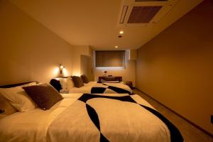 a hotel room with two beds in a room at Open記念セール!! AXIS STAY asahikawa36 旭川街中に佇むLuxury Stay in Asahikawa