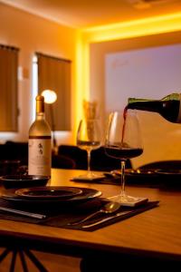 a bottle of wine is being poured into a wine glass at Open記念セール!! AXIS STAY asahikawa36 旭川街中に佇むLuxury Stay in Asahikawa