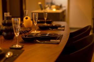 a wooden table with wine glasses on top of it at Open記念セール!! AXIS STAY asahikawa36 旭川街中に佇むLuxury Stay in Asahikawa