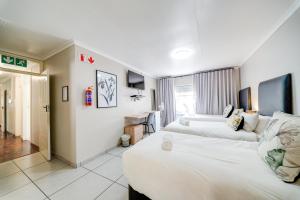 a hotel room with two beds and a desk at 18 Goethe in Secunda