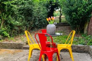 three chairs and a table with a vase of tulips at Modern Bletchley home with stylish decor in Bletchley
