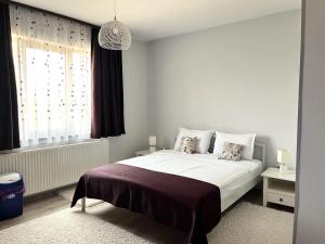 a bedroom with a large white bed with a window at Villa Petra Residence - Private Parking & Village Life in Cristian