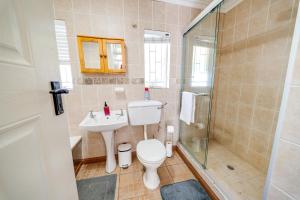 a bathroom with a toilet and a sink and a shower at 18 Goethe in Secunda +27 photos
