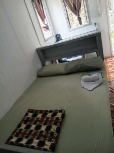 a bed in a tiny house with a checkered blanket at GoodWorks Accommodation in Yangor