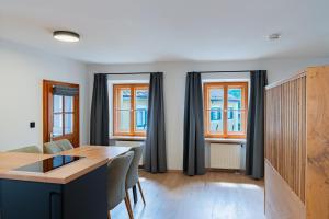 a living room with a table and some windows at N47 Apartments Berchtesgaden in Berchtesgaden