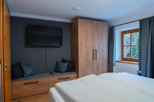 a bedroom with a bed and a tv on the wall at N47 Apartments Berchtesgaden in Berchtesgaden