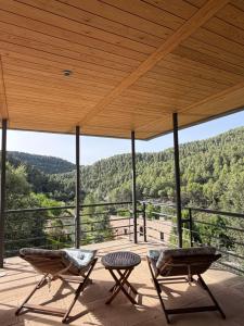 two chairs and a table on a deck with a view at Villa Natalia in Monroyo