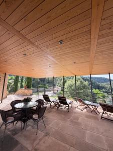 a patio with a table and chairs and a large wooden ceiling at Villa Natalia in Monroyo