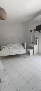 a white bedroom with a bed and a tiled floor at Merichas 7 Irida in Mérikhas