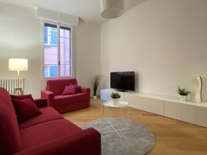 a living room with two red couches and a tv at Porta Nova, Bologna by Short Holidays in Bologna