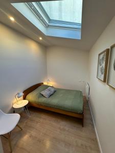 a bedroom with a bed and a skylight at La lumière d'Issy in Vanves