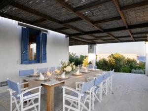 a long table and chairs on a patio at VILLA SOROS in Antiparos
