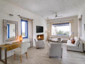 a living room with white furniture and a fireplace at VILLA SOROS in Antiparos