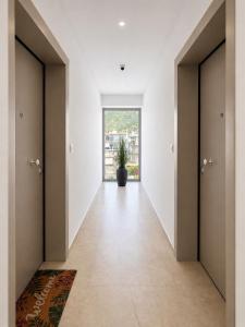 a hallway with two doors and a potted plant at AGORA luxury APARTMENT 3 in Loutraki
