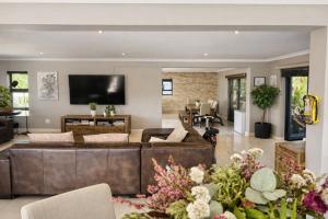 a living room with a brown leather couch at Salt and stone in Cape Town