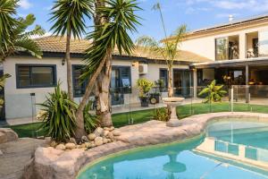 a house with a swimming pool in front of a house at Salt and stone in Cape Town
