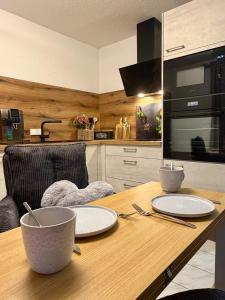 a kitchen with a wooden table with plates on it at Ferienwohnung Hopfentraum in Alpirsbach