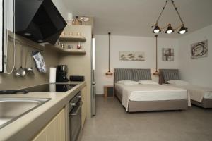 a kitchen with a sink and a bed in a room at Onar Sifnos by the sea in Cherronisos