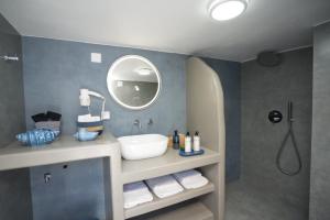 a bathroom with a sink and a mirror at Onar Sifnos by the sea in Cherronisos