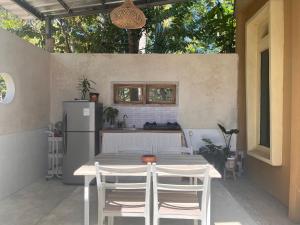 a kitchen with a table and chairs and a refrigerator at Sanghiang Homestay in Batukaras