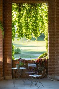 a table and two chairs in front of a window at B&B Tenuta Castello Golf Club in Cerrione +52 photos