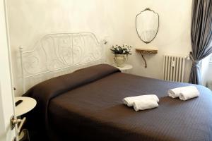 ローマにあるLa Rosa del Vaticano Luxury Apartmentのベッドルーム1室(大型ベッド1台、タオル2枚付)
