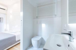 a white bathroom with a toilet and a sink at Garisenda, Bologna by Short Holidays in Bologna