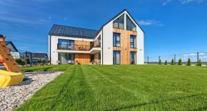 a large house on a grassy field at GERALT Tatras Residence in Nová Lesná